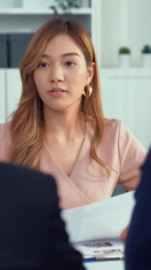 A young female asian candidate tries to impress her interviewer by being competent. International company, multicultural environment in workplace.