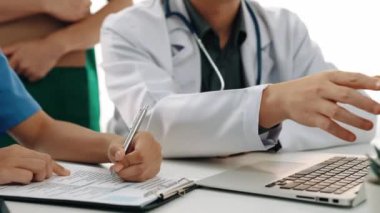 Hasta için hastane masasında çalışan ve tıbbi tedavi planlayanlardan oluşan profesyonel bir ekip. Takım çalışması başarılı hastalıklara ve hastalıklara yol açar. Ağır çekim. Katı.