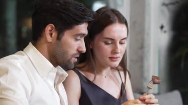 Çift, lüks bir restoranda özel bir yemekte ızgara et yemeği yiyor. Özel masa partisi veren grup arkadaşlarıyla mutluluk dolu bir an yaşıyor. Vinosity.