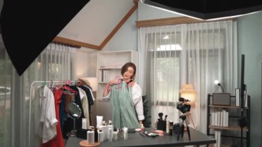 Kadın nüfuzlu kişi video görüntülerini canlı yayınlıyor. Kıyafetler sosyal medyada ya da blogda yer alıyor. Stüdyo ışıklandırmalı mutlu genç kız çevrimiçi pazarlama oturumu yayını için..