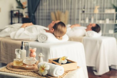 Aromaterapi masajı gündüz atmosferinde ya da spa salonunda bulanık bir kadına odak dekor ve spa aksesuarları kurarak tatil köyünde ya da otel arka planında keyifli aroma spa masajı yapan bir masaj. Sessiz.