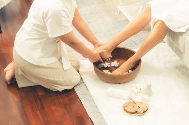 Kadınlar lüks spa salonlarında keyifli ayak masajlarına devam ederken, masör de hafif gün ışığı atmosferinde refleksoloji terapisi veya otel ayak spa 'sında. Sessiz.