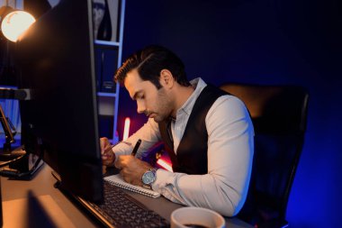 Stresli akıllı işadamı, kağıt işleri üzerine not pazarı verileri yazarak, gece geç saatlerde mor neon karanlık aydınlatma odasındaki disiplin ürünü hizmetlerinin çevrimiçi satış kanalını analiz ediyor. Tahmin et..