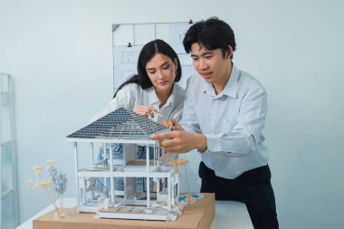 Kooperatif mühendis ekibinin portresi ev modelini ölçmek için cetvel ve mimari ekipmanlar kullanarak birlikte çalışıyor. Yaratıcı iş tasarımı ve takım çalışması konsepti. Tertemiz...