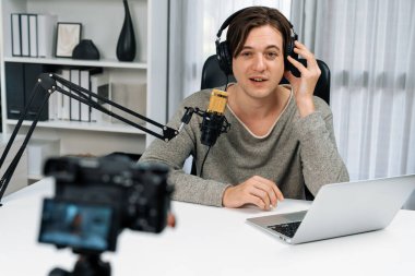 Akıllı yayın kanalının sunucusu kamerayla kayıt yapıyor sosyal medyada canlı yayın yapıyor, sosyal medyada yayın yapıyor, kulaklık takıyor ve modern stüdyoda video kaydediyor. Bireysel.