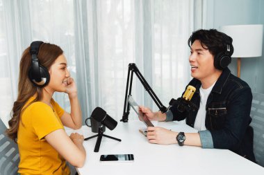 Gülümseyen radyo etkili sunucu elinde tablet, kulaklık takıyor kadın konuşmacı sosyal medya online canlı yayın kanalı ile röportaj yapıyor ve sabah stüdyo kaydında paylaşım linkini paylaşıyor. İnfobahn.