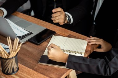Proaktif iş kadını aktif olarak üretken iş toplantılarına katılıyor, stratejik pazarlama planlaması için mali veri tablosuyla birlikte iş arkadaşlarıyla fikir alışverişinde bulunuyor. Çok titiz.