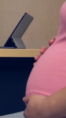 Mutlu hamile kadın, jinekolog doktoru hastanede ya da klinikte hamilelik danışmanlığı için ziyaret ediyor. Doktor, bebek ve anne sağlığı kontrolü için hamile karnı muayene ediyor. Jinekoloji konsepti.