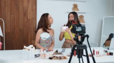 Etkilenen iki ortak canlı yayın yapan video görüntülerini sosyal medya ya da blog üzerinden gözden geçirir. Canlı kozmetik stüdyosu ışıklandırması olan mutlu genç bir kız pazarlama için internet üzerinden yayın yapıyor..