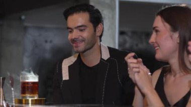 Duman çıkaran dumanlı bir barmen kokteyl sunumuyla viskiyi karıştırıyor. Grup misafirlerine içki tezgahında özel hoş geldin içkisi öneriyor. Vinosity.