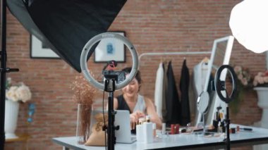Kadın nüfuzlu kişi sosyal medya ya da blog için canlı yayın yapan video klip eleştirmeni derisini çekiyor. Canlı kozmetik stüdyosu ışıklandırması olan mutlu genç bir kız pazarlama için internet üzerinden yayın yapıyor..