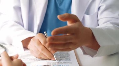 Hastanedeki doktor masasında oturup hasta test sonuçlarını teşhis eden, hastalıklar ve hastalıklar için tedavi planı geliştiren evrak işleriyle uğraşıyor. Sağlık personeli ve sağlık hizmetleri. Ağır çekim. Katı.