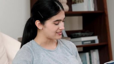 Kanepede oturan bir kadın ders kitabı okuyarak sosyal ve mesleki teknoloji bilgisini artırır ya da akıllı bir anne olmak için çocuk yetiştirir. Hayat boyu öğrenme konsepti. Uyumsuzluk.