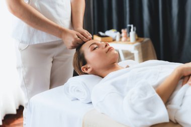 Kafkasyalı kadın stres önleyici kafa masajından ve lüks tatil beldesi ya da otel spa salonundaki modern ışık ortamında yüz güzelliği eğlencelerini şımartmaktan hoşlanıyor. Sessiz.
