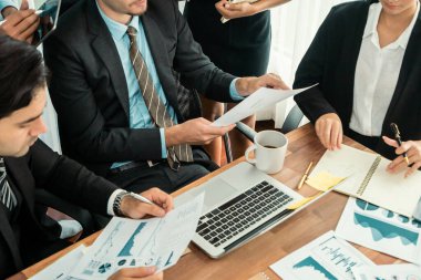 Ofis masasındaki finansal veri raporlarını analiz eden çeşitli bir grup iş analisti. Stratejik pazarlama planlaması için iş istihbarat analizine göre grafikler ve grafikler.