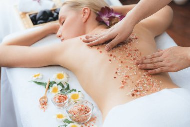 Lüks spa salonlarında sıcak mum ışığında cilt bakımı yaptıran kadın müşteri. Sağlık Spa vücut fırçasında tuz temizleme güzellik tedavisi. Sessiz.