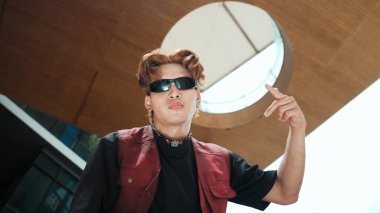 Kameraya poz veren modern dansçı ve düşük açılı kamera. Hip hop tarzında dans eden genç hip hop dansçısının portresi. Açık hava sporu 2024. Hareket atışı. Serbest stil. hiphop.