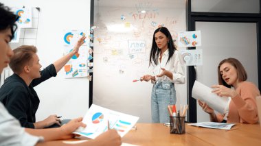 Genç ve yakışıklı beyaz adamın el kaldırması ve soru sorması. Bu arada genç ve güzel lider iş görüşmeleri arasında zihin haritası ve renkli grafikler kullanarak iş planı sunuyor. Tertemiz..