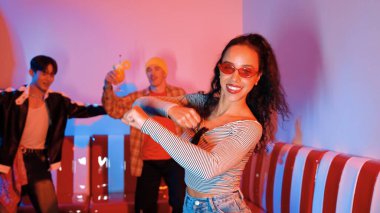 Çok kültürlü bir arkadaş birlikte dans ediyor ve hiphop müziği eşliğinde restoranda ya da kafede pembe neon ışıklı duruyor. Profesyonel sokak dansçıları grubu enerjik hareketler sergiliyor. Mutluluk.