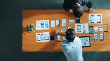 Ux Ui tasarımı üzerinde çalışan yazılım geliştiricisinin en üst görüntüsü. Ekip birlikte çalışarak yaratıcı dijital şirkette wirefram prototipi tasarlıyor. Takım çalışması konsepti. Cemaat.