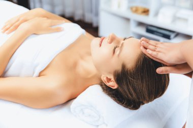 Kafkasyalı kadın stres önleyici kafa masajından ve lüks tatil beldesi ya da otel spa salonundaki modern ışık ortamında yüz güzelliği eğlencelerini şımartmaktan hoşlanıyor. Sessiz.