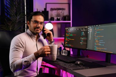 Bilgisayar ekranındaki yazılım geliştirme kodlarında kahve fincanı tutan akıllı bilişim geliştiricisi profili. Program güncellemesi internet sitesi verilerini neon ışığı siber ofisinde sunuyor. Tahmin et..