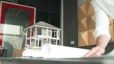 Profesyonel Kafkas erkek mimar mühendisinin yakından incelemesi ve ev modeli inşaatını proje planı ve mimari modelle kontrol etmesi. İş tasarımı konsepti. Yönlendirici.