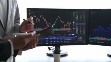 Menkul kıymetler borsası pazarlamasını inceleyen borsa yatırımcıları, zarar ve kazanç için mum bar fiyatlarını analiz eden monitörlere bakıyor. Filizlenen
