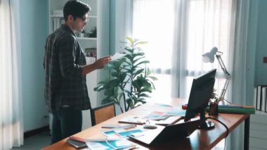 Akıllı iş adamının yönetici çağırırken rengini seçtiğinin en üst görüntüsü. Toplantıda ürün için ana tema rengini seçerken ve tasarlarken dizüstü bilgisayara bakan profesyonel iç mimar. Sempozyum.