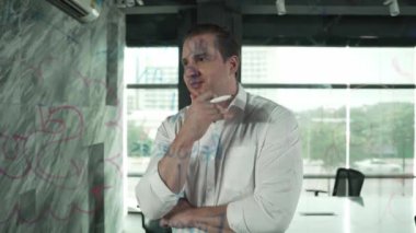 Profesyonel erkek lider yapışkan notlar üzerine pazarlama fikri yazıyor. Kafkasyalı işadamı cam duvarda renkli yapışkan notlar kullanırken pazarlama kampanyasını düşünüyor. - Yakın çekim. Yönlendirici.