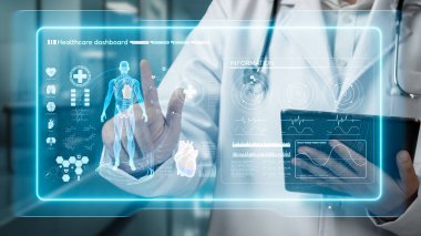 Doktorun elinde tablet varken ve laboratuvarda yüzen insan anatomisi hologramına bakarken. Semptomu teşhis ederken ve tıbbi verilerle çalışırken teknoloji yeniliklerini kullanan bir tıp çalışanı. İyileştirici.