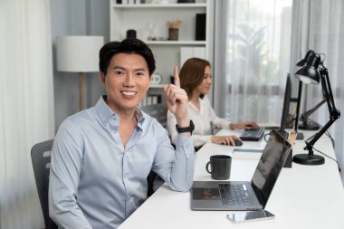 Akıllı Asyalı iş adamının profil profili modern ofisteki reklam alanı için kamera görüntüsü veriyor. Bulanık arkaplan bayan meslektaşım e-posta pazarlama raporunu kontrol etmek için bilgisayar üzerinde çalışıyor. İnfobahn.