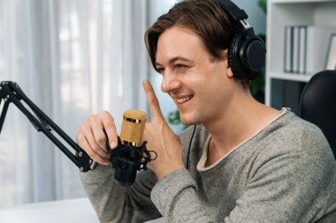 Sunucu kanalı, gülümseyen akıllı yayıncı kaydı, senaryosu ve akıllı telefonuyla sosyal medyada sohbet programı, kulaklık takarak modern ev stüdyosundaki video flamalarını kaydediyor. Bireysel.