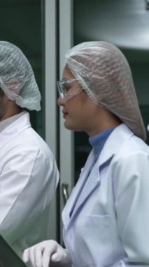 Two scientist in professional uniform working in curative laboratory for chemical and biomedical experiment