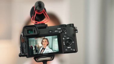 Arka görünüm, kamera ekranında kadın nüfuzunu gizler. Video görüntüleme, video görüntüleme, giysi, sosyal medya ya da blog. Canlı yayın için stüdyo ışıklandırması olan bir kız.