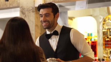 Yakışıklı, güler yüzlü, zeki barmen arkadaş canlısı sohbet VIP müşteriyle konuşurken lüks içki tezgahı sahnesinde cam siliyormuş. Profesyonel barmen kostümlü sanırım. Vinosity.