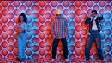 Parti sahnesinde kameraya bakarken balon geçmişiyle birlikte dans eden mutlu çok kültürlü dansçılar. Zeki hipster grubu müzik yapıyor ve sokak dansı yapıyor. Tam vücut. Mutluluk.