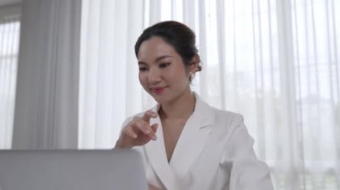 Çalışma masasında internet içeriği için dizüstü bilgisayar kullanan genç bir iş kadını ya da evden çalışan bir sekreter. Canlılık