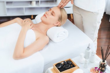 Kafkasyalı kadın stres önleyici kafa masajından ve lüks tatil beldesi ya da otel spa salonundaki modern ışık ortamında yüz güzelliği eğlencelerini şımartmaktan hoşlanıyor. Sessiz.
