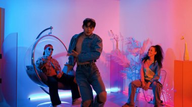 Çok kültürlü bir arkadaş kürsüde otururken Asyalı yetenekli bir dansçı modern müziğe geçiyor. Profesyonel dansçı, hipster takımı tezahürat yaparken ve desteklerken enerjik adımlar atıyor. Mutluluk.