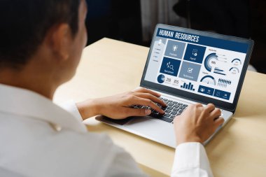 Human resources management software on computer screen helping human resources employee to manage recruitment, payroll, staff searching and KPI evaluation snugly