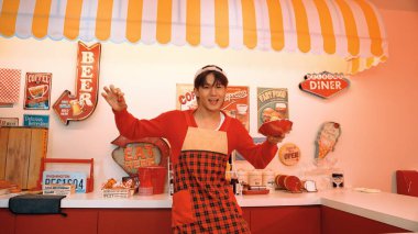 Profesyonel Asyalı restoran işçisi yemek hazırlar ve yemek barının arkasında durur. Kırmızı önlüklü çekici garson kameraya bakarken vişne topluyor. Çılgın dans. Mutluluk.