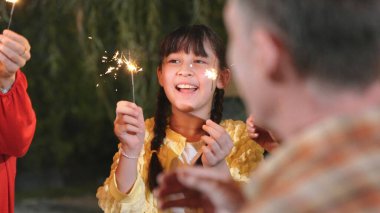 Tatil kutlamalarında yaşlı çiftlerin gözü önünde maytap tutan bir kız. Sevimli bir aile birlikte kıvılcım oynamaktan hoşlanır. Çoklu nesil konsept çapraz nesil farkı aile bağını güçlendirir. Uyumsuzluk.