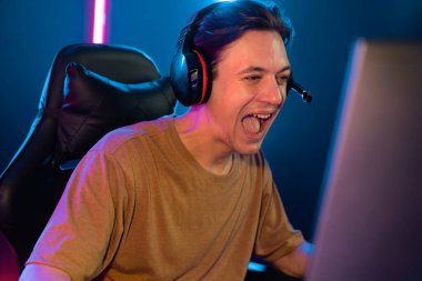 Kazanmak için çevrimiçi oyun oynayan akıllı flama makinesinin sunucu kanalı, neon ışıklı odada seçilen takım yarışması için izleyicilerle birlikte canlı yayında canlı yayında kulaklık takıyor. Bireysel.