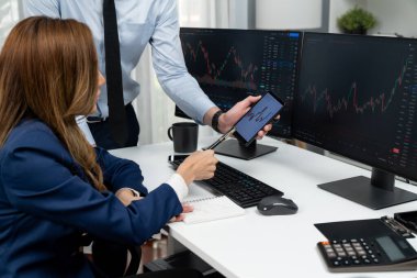 Kâr değeri değeri oranı online web sitesi uygulamasını ev ofisinde analiz etmek için notlar yazan kadınlara telefonda dinamik borsa verilerini gösteren bir işadamı eli kesilmiş. İnfobahn.