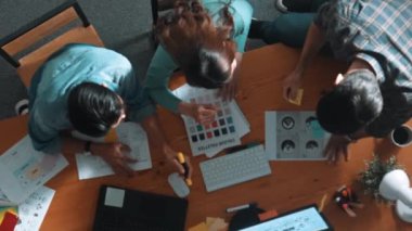 Ekip toplantısına katılıp fikir hakkında konuşurken proje yöneticisinin yazma fikrinin en üst görüntüsü. Renk paletine bakarken ve kağıda fikir yazarken profesyonel tasarımcı logosu. Sempozyum.