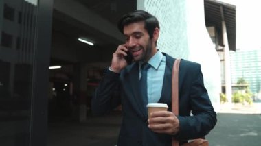 İş adamı telefona cevap verir ve iş yatırımları hakkında konuşur. İş planı, pazarlama stratejisi ya da çalışma hakkında konuşmak için akıllı telefonla konuşurken sokakta yürüyen mutlu bir yönetici. Sevinçli..