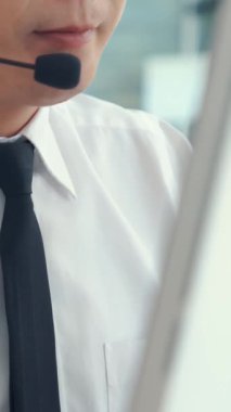 Kulaklık takan bir iş adamı ofiste çalışıyor. Arama merkezi, tele pazarlama, müşteri destek acentesi telefon görüşmesinde hizmet sunar.