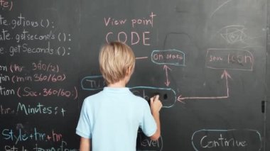 Tahtaya yazı yazan öğrencilerin arka planı. Yakışıklı zeki çocuk ya da çocuk BTMM teknoloji sınıfında kodlama ve programlama sistemi kullanarak bir proje planlıyor. - Yakın çekim. Etkinlik.