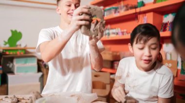 Akıllı çocuk çömlek atölyesindeki deliğe bakarken kil topluyor. Sanat dersinde mutlu çocuğa gülerken çeşitli lise öğrencilerinin çalışıp mangır mankenliği yapıyor. Yaratıcı sanat. Öğretim